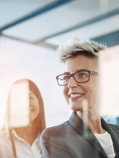 Auf dem Bild sieht man eine lächelnde Frau in der Seitenperspektive.